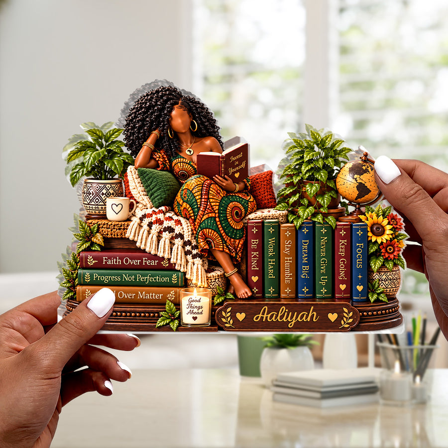 Hands holding the personalized plaque in front of a bookshelf